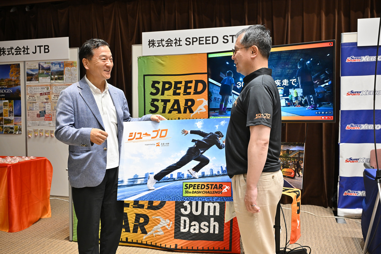 河合純一スポーツ庁長官が株式会社SPEED STARのブースで説明を受けている画像